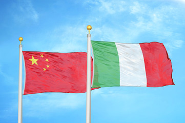 China and Italy two flags on flagpoles and blue cloudy sky
