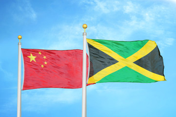 China and Jamaica two flags on flagpoles and blue cloudy sky