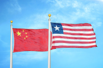 China and Liberia two flags on flagpoles and blue cloudy sky