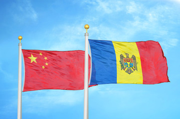 China and Moldova two flags on flagpoles and blue cloudy sky
