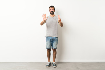 A full-length shot of handsome man with beard counting seven with fingers