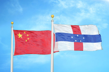 China and Netherlands Antilles two flags on flagpoles and blue cloudy sky