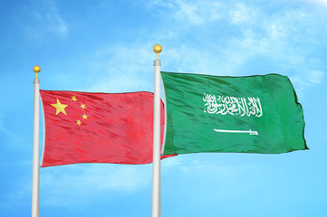 China and Saudi Arabia two flags on flagpoles and blue cloudy sky