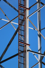 Power and signal cables on telecommunication tower against blue sky