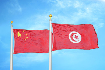 China and Tunisia two flags on flagpoles and blue cloudy sky