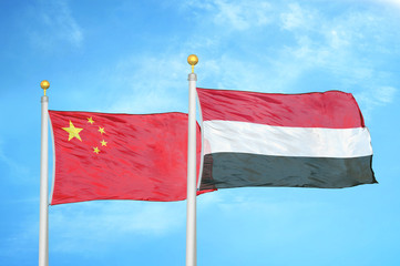 China and Yemen two flags on flagpoles and blue cloudy sky