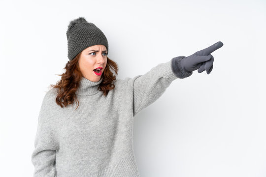 Young Russian Woman With Winter Hat Over Isolated White Background Pointing Away