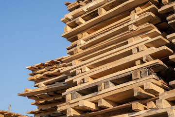 Wooden euro pallets for transfering goods to customers. Used wooden pallets in stack in the warehouse. Wooden pallet overlap.