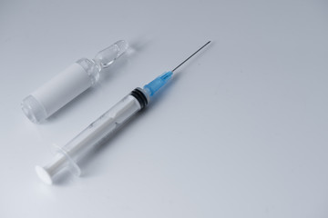 Medical vial for injection and a syringe,lays on the white table background
