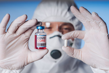 A bottle with a cure and pill holds a palm in silicone gloves in a policlinic. A breakthrough in...