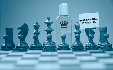 Coronavirus concept image chess pieces and hand sanitizer on chessboard illustrating global struggle against novel covid-19 outbreak with hand sanitizer is the king sign.