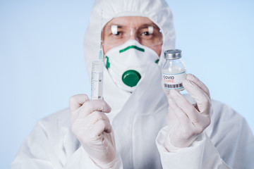 The doctor gets the cure into the syringe. Glass medical bottle in a doctor's hand. A bottle with a...