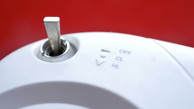 Hands turning the radio control switch on and off. Mini lever metal toggle switch - plated lever. An engine control unit ECU. Close up, Shallow depth of field 