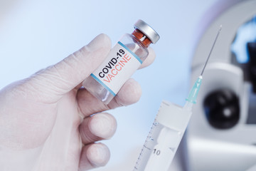 The nurse gets the vaccine into the syringe. Glass medical bottle in a doctor's hand. A bottle with...