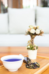 cup of tea with spoon of herbs 