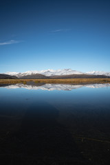 Snow Covered Mountain Landscape in Iceland with reflection in the water 