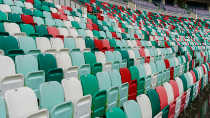 Fototapeta premium Empty multi-colored plastic seats with numbers at the stadium. Sport concept.
