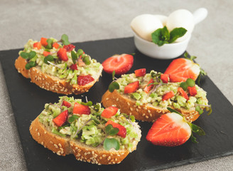 toast with guacamole, avocado, strawberries. mozzarella cheese. healthy eating