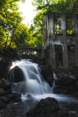 waterfall in the woods with old rustic building 