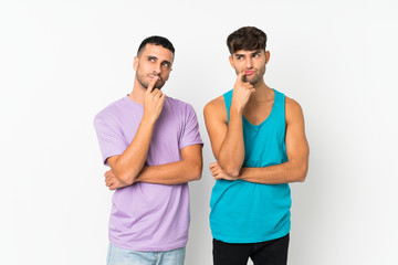 Obraz premium Two men over isolated background having doubts while looking up