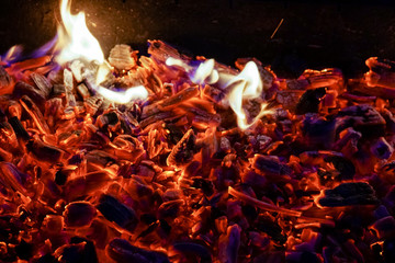 Burning firewood in the fireplace close up, BBQ fire, charcoal background. Charcoal fire with sparks