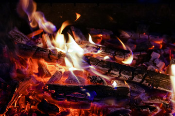 Burning firewood in the fireplace close up, BBQ fire, charcoal background. Charcoal fire with sparks