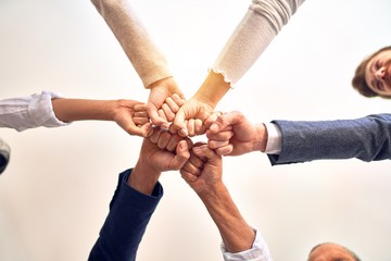 Group of business workers standing bumping fists at the office
