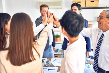 Obraz premium Group of business workers standing with hands together at the office