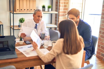 Group of business workers working together. Sitting on desk using laptop reading documents at the office