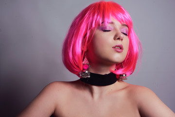 Portrait of a girl with pink hair and chic, fashionable  earrings, pink earrings with silver. Jewelry, accessories. Stylish girl in a checker and means. Girl with pink make-up. Professional makeup.