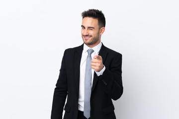 Young business man over isolated background points finger at you