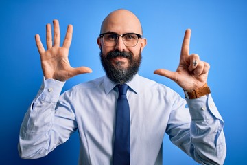 Handsome business bald man with beard wearing elegant tie and glasses over blue background showing and pointing up with fingers number seven while smiling confident and happy.