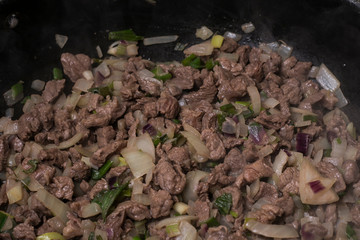 Some cooked beef meat, onion and green pepper in a wok