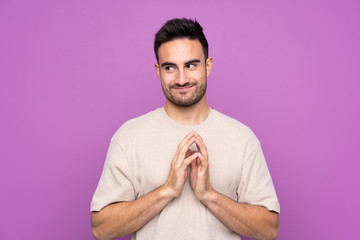 Young handsome man over isolated purple background scheming something