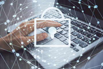 Double exposure of woman hands working on computer and lock hologram drawing. Security concept.
