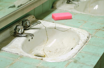 Broken old washbasin. Vintage sink found in abandoned bathroom