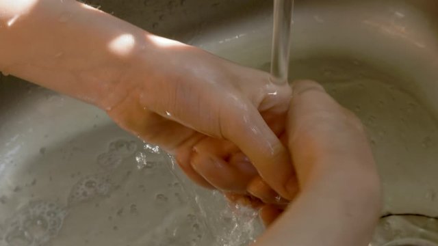 child wash hands in kitchen sink