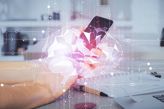 Double exposure of man's hand holding and using a digital device and brain hologram drawing. Data concept.