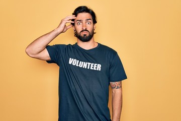 Young handsome hispanic volunteer man wearing volunteering t-shirt as social care worried and stressed about a problem with hand on forehead, nervous and anxious for crisis