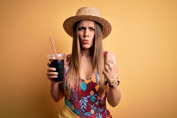 Young beautiful blonde woman on summer drinking fresh soda over isolated yellow background annoyed and frustrated shouting with anger, crazy and yelling with raised hand, anger concept
