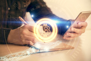 Double exposure of blockchain business sketch hologram and woman holding and using a mobile device.