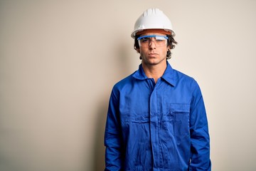 Young constructor man wearing uniform and security helmet over isolated white background skeptic and nervous, frowning upset because of problem. Negative person.