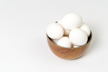 Eggs isolated in wooden bowl on white background