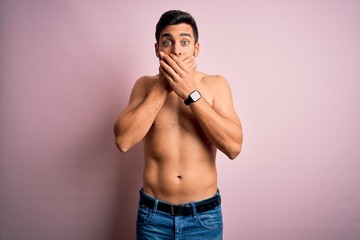 Fototapeta premium Young handsome strong man with beard shirtless standing over isolated pink background shocked covering mouth with hands for mistake. Secret concept.