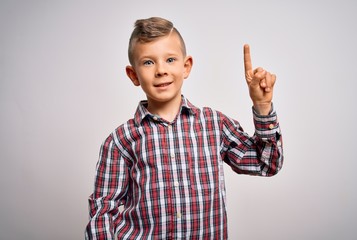 Young little caucasian kid with blue eyes wearing elegant shirt standing over isolated background showing and pointing up with finger number one while smiling confident and happy.