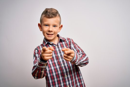 Young little caucasian kid with blue eyes wearing elegant shirt standing over isolated background pointing fingers to camera with happy and funny face. Good energy and vibes.