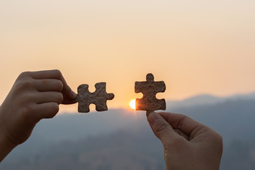 hands holding piece of red jigsaw puzzle. teamwork concept