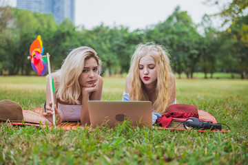 Two young women friends watching social media videos blogs