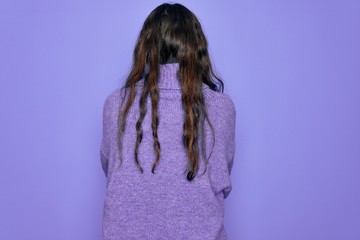 Young beautiful woman wearing casual turtleneck sweater standing over purple background standing backwards looking away with crossed arms