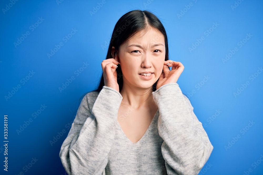 Sticker young beautiful asian woman wearing casual sweater standing over blue isolated background covering e